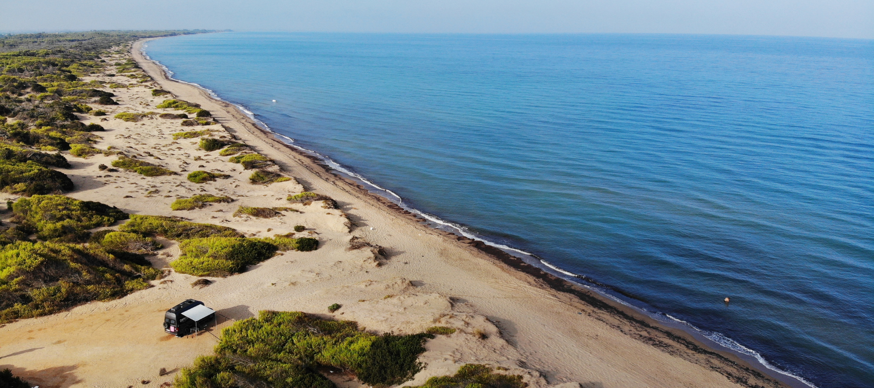 Der Campnetic Campervan steht an einem Strand. Diesen Spot hat er sorglos erreicht, dank der magnetischen sanboards, welche ohne Bohren am Campervan befestigt sind.