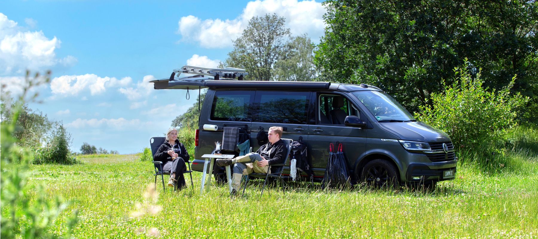 Campnetic magnetisches Campingzubehör angebracht mit Magneten am VW California mit Campern davor.